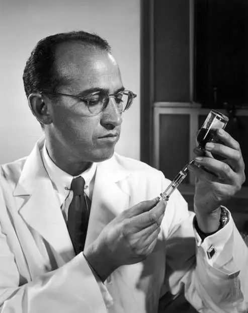 r Jonas Salk penemu vaksin polio sedang bekerja di laboratorium sebagai ilustrasi kisah inspiratif kemanusiaan
